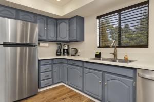 een keuken met blauwe kasten en een roestvrijstalen koelkast bij 2169-Whispering Forest Chalet chalet in Big Bear City