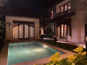 una piscina frente a una casa por la noche en Jimbaran BeachStroll Villa (3BR), en Jimbaran