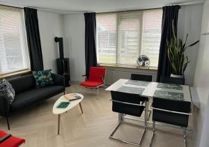 uma sala de estar com um sofá e uma mesa em Waddenhoes Gastenverblijven em Pieterburen