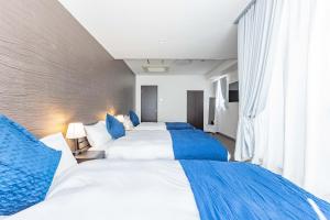 大阪市にあるART NAMBA HIGASHI 2Fのホテルルーム ベッド3台(青い枕付)