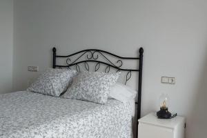 - un lit avec une couette et des oreillers en noir et blanc dans l'établissement OVIEDO TORRES HUCA VUT2752AS, à Oviedo
