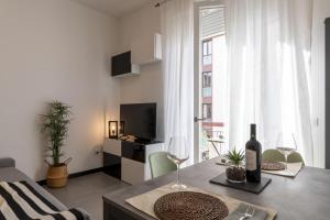 uma sala de estar com uma mesa e dois copos de vinho em Aeroporto - Modern Apartment em Florença