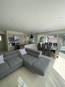 a living room with a couch and a kitchen at Villa Le week end in Ajaccio