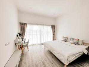 a white bedroom with a bed and a window at First pool villa พลูวิลล่าโคราช in Nakhon Ratchasima