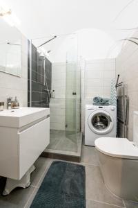 uma casa de banho com um lavatório e uma máquina de lavar roupa em Hlavna Apartment Kosice em Košice
