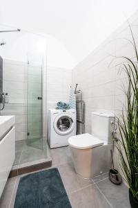 a bathroom with a toilet and a washing machine at Hlavna Apartment Kosice in Košice