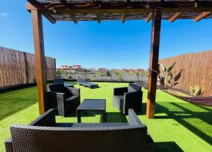 a patio with chairs and a hammock in a yard at Villa Twins in Lajares