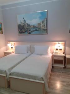 a bedroom with a bed and two night tables with lamps at Hotel Guri in Elbasan