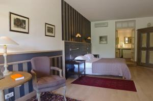 レ・ゼイジー・ド・タヤックにあるLes Glycines - Hôtel & Spa - Teritoriaのベッドルーム1室(ベッド1台、デスク、椅子付)