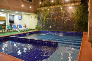 una piscina con azulejos azules en un edificio en Arthur Palace Hotel, en Encarnación