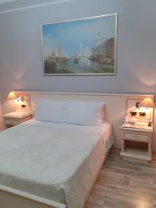 a bedroom with a large bed with two night stands at Hotel Guri in Elbasan