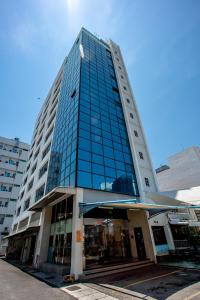 a tall building with glass windows on a street at PP Hotel by Moxy in George Town