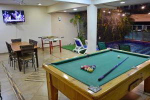 a pool table in the middle of a room with a swimming pool at Arthur Palace Hotel in Encarnación