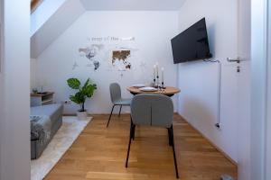 comedor con mesa y nevera en Rooftop cozy apartment near innerstadt with AC, en Viena
