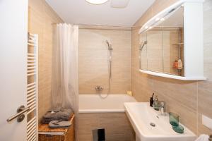 a bathroom with a tub and a sink and a shower at Rooftop cozy apartment near innerstadt with AC in Vienna +34 photos