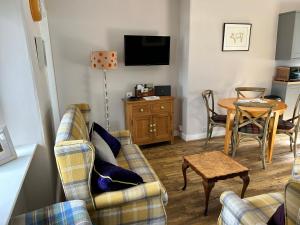 uma sala de estar com dois sofás e uma mesa em Lottie’s Cottage, Rhynie, Aberdeenshire em Rhynie