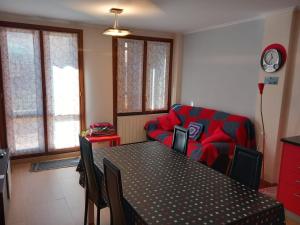 a living room with a table and a red couch at Apartamento Villa Maritxu in Ezcaray