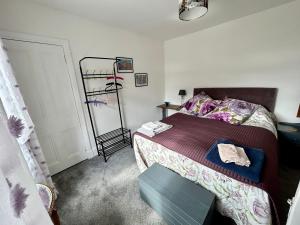 a small bedroom with a bed and a mirror at Lottie’s Cottage, Rhynie, Aberdeenshire in Rhynie