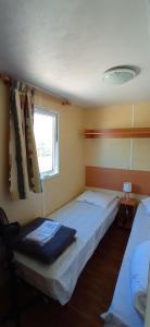 a bedroom with two beds and a window at CAMPING LE BEL AIR- Mobil home le laurier in Limogne-en-Quercy