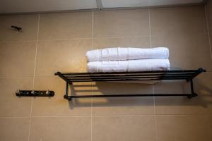 a towel rack with towels on it in a bathroom at PP Hotel by Moxy in George Town