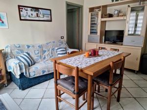 羅西尼亞諾蘇威的住宿－Appartamento Caletta，客厅配有桌子和沙发