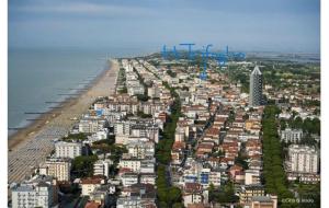 eine Luftansicht auf eine Stadt mit Strand und Gebäuden in der Unterkunft Hotel Trifoglio in Lido di Jesolo