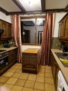 a kitchen with wooden cabinets and a large window at DrKarlRennerGarten in Guntramsdorf