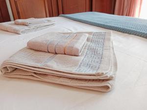 two towels are sitting on top of a bed at Nakhah Guesthouse - Private Interior in eMalahleni