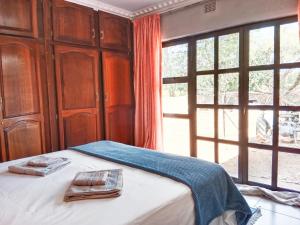 a bedroom with a bed and a large window at Nakhah Guesthouse - Private Interior in eMalahleni