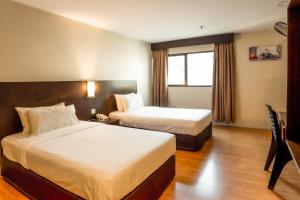 a hotel room with two beds and a window at PP Hotel by Moxy in George Town