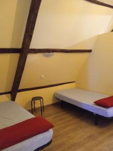 Habitación pequeña con cama y taburete. en Albergue de peregrinos Compostela, en Molinaseca