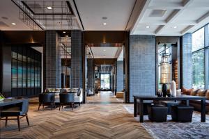 a lobby of a building with tables and chairs at Houston CityPlace Marriott at Springwoods Village in The Woodlands