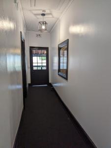 a hallway with a door and a mirror on a wall at Toodyay Manor in Toodyay