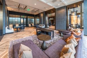a lobby with a couch and a table and chairs at Houston CityPlace Marriott at Springwoods Village in The Woodlands