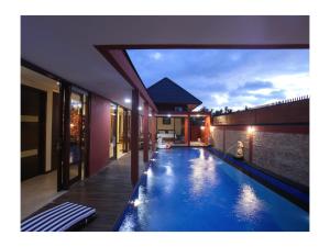 a swimming pool in the middle of a house at Dawn Light Villa, Sire in Tanjung