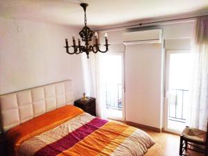 a bedroom with a bed and a chandelier at Casa Blanca in Cuevas del Becerro