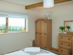 a bedroom with a wooden cabinet and a window at Annies in Bridestowe