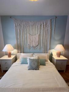 a bedroom with a white bed with two night stands at My Ocean - Cliff & Ocean View in Acantilado de los Gigantes