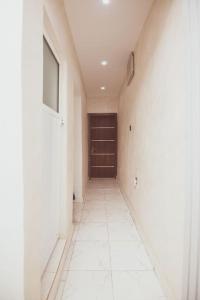 a hallway with a door and a white tile floor at Cozy home away from home in Lagos