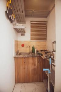 una cocina con armarios de madera y fregadero en Cozy home away from home, en Lagos