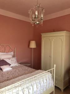 a bedroom with a bed and a chandelier at Masia Quelet in La Vall de Bianya