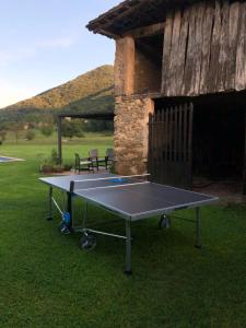 una mesa de ping pong frente a un edificio en Masia Quelet, en La Vall de Bianya