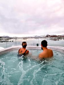 two people sitting in a jacuzzi bathtub at Ringstad Resort in Bø