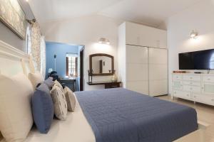 una camera con un grande letto e una televisione di StayVista at The Haven - Grandeur with Breakfast & BBQ Grill a Madikeri