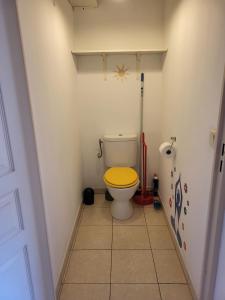 uma casa de banho com um WC com uma tampa amarela em Appartement traversant et lumineux avec terrasse em Saint-Laurent-du-Var