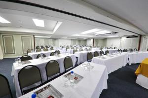 einen Konferenzraum mit weißen Tischen und Stühlen in der Unterkunft Hotel Continental Porto Alegre e Centro de Eventos in Porto Alegre