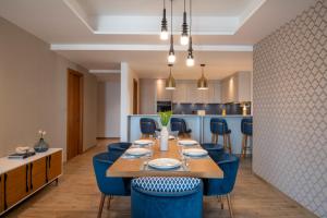 a dining room with a table and blue chairs at Abesq Doha Hotel and Residences in Doha