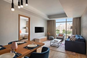 a room with a dining table and a living room at Abesq Doha Hotel and Residences in Doha