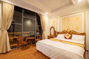 - une chambre avec un lit, un bureau et une fenêtre dans l'établissement TRÍ TÂM HOTEL - Khách sạn TRÍ TÂM Bến Lức, à Bến Lức