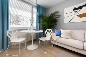 a living room with a couch and a table and chairs at Apartament Bielany 3 min from metro with 5-meals per day customisable diet catering and free parking in Warsaw